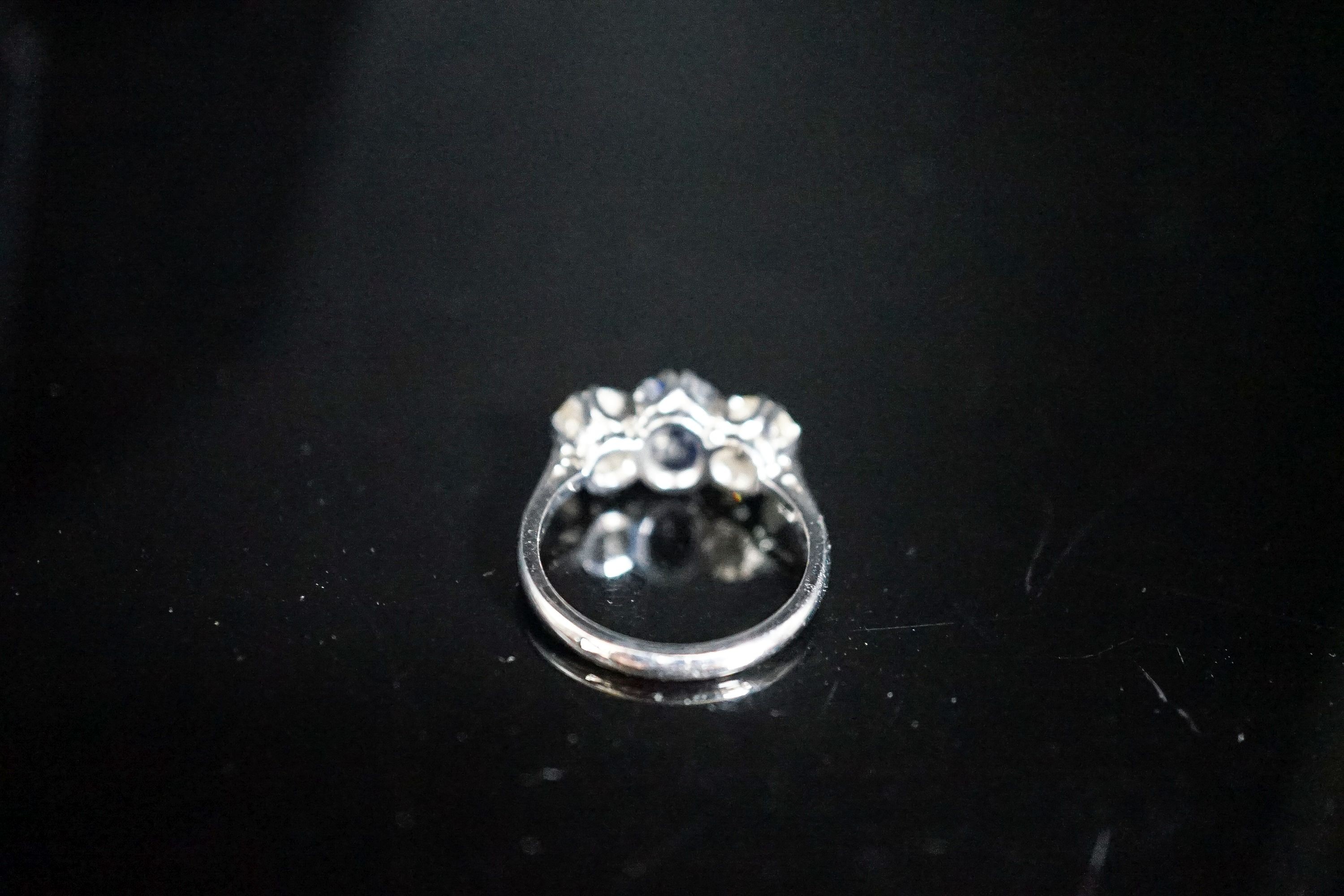 A modern 18ct white gold, single stone sapphire and two stone diamond set ring, size L, gross weight 4.2 grams